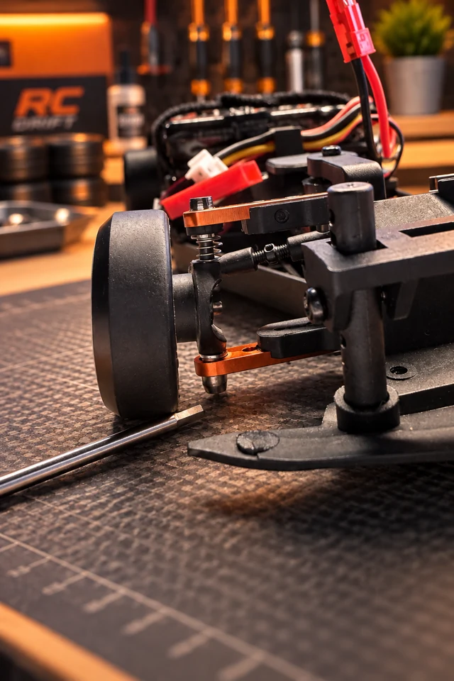 Lower front suspension bush near the workbench surface, indicated by a tool