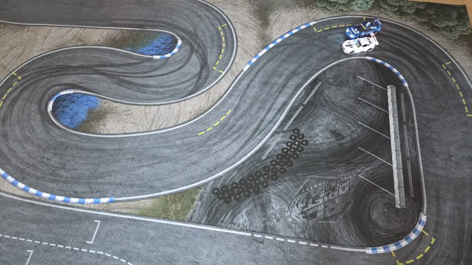 Zwei RC-Driftautos auf einer Driftstrecke mit blauer Kurve
