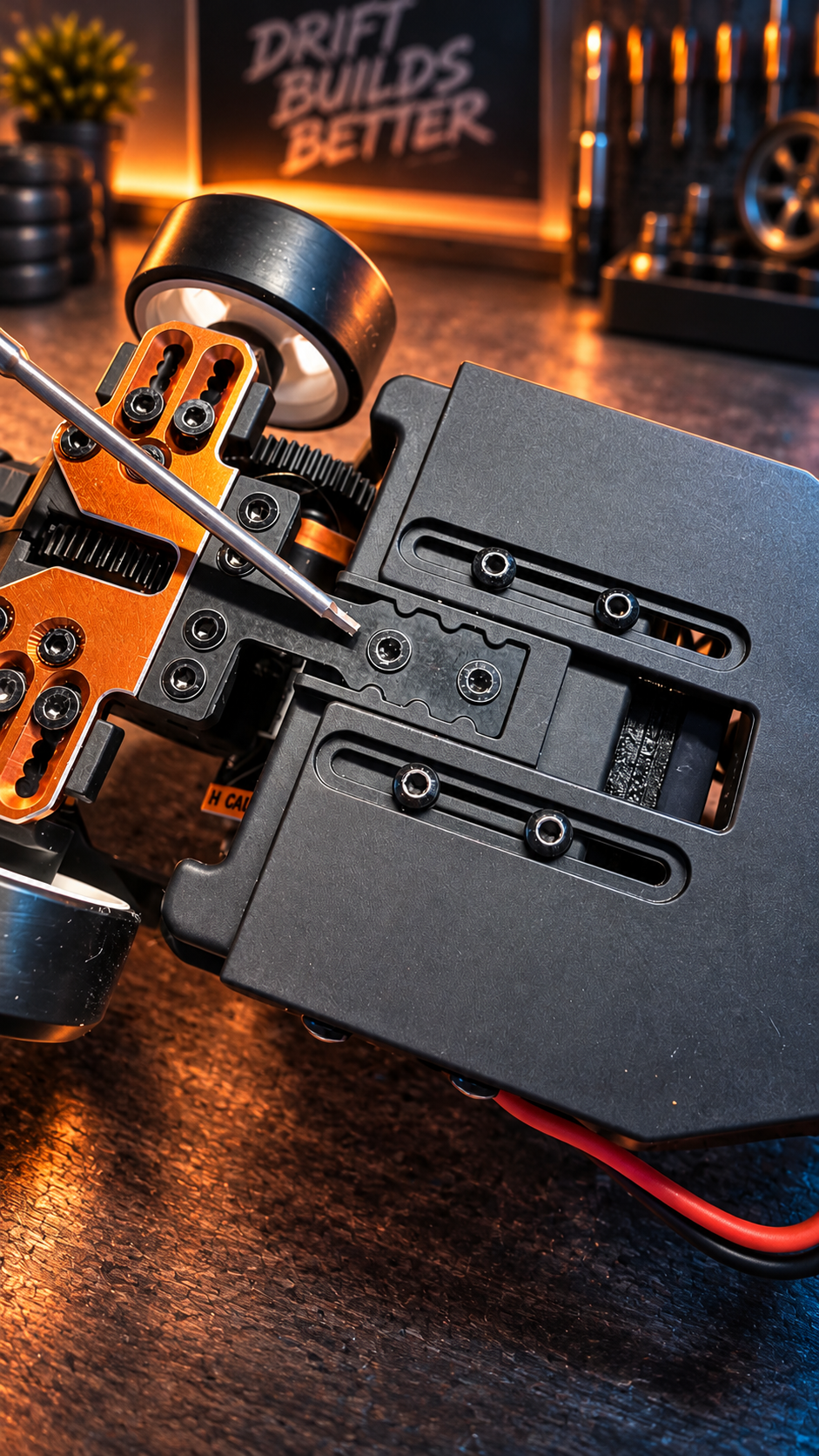 Underside of the HPI chassis with a tool pointing at the T-bar mounting area between the main chassis plates