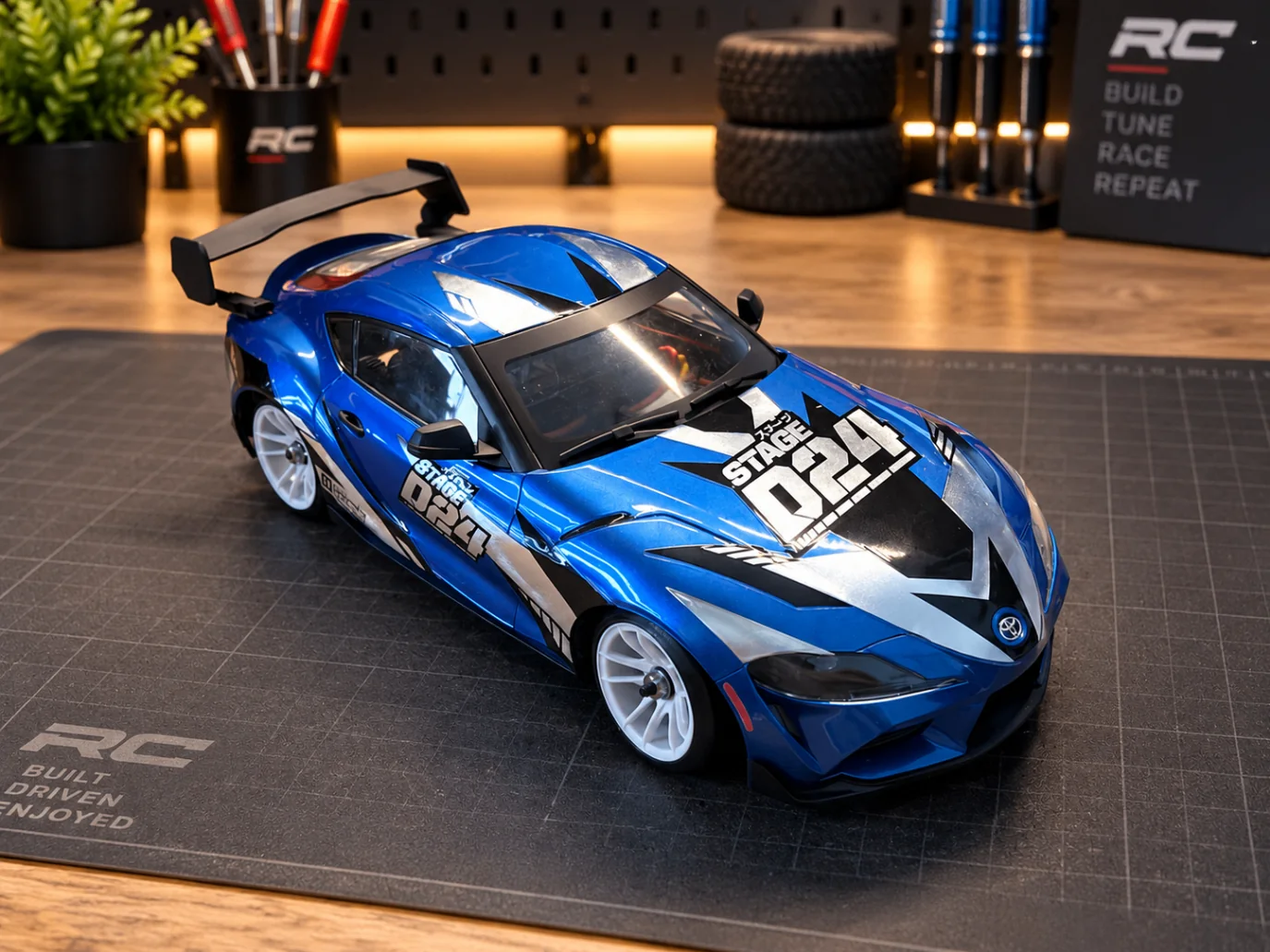 Blue HPI Stage-D24 Toyota GR Supra from the front on a cutting mat in the workshop