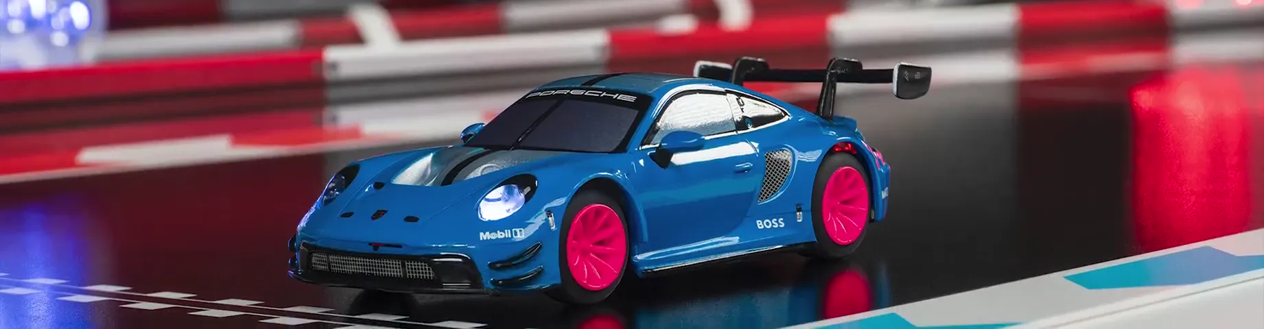 Nahaufnahme eines blauen Modellfahrzeugs neben einer Bahn mit Randsteinen